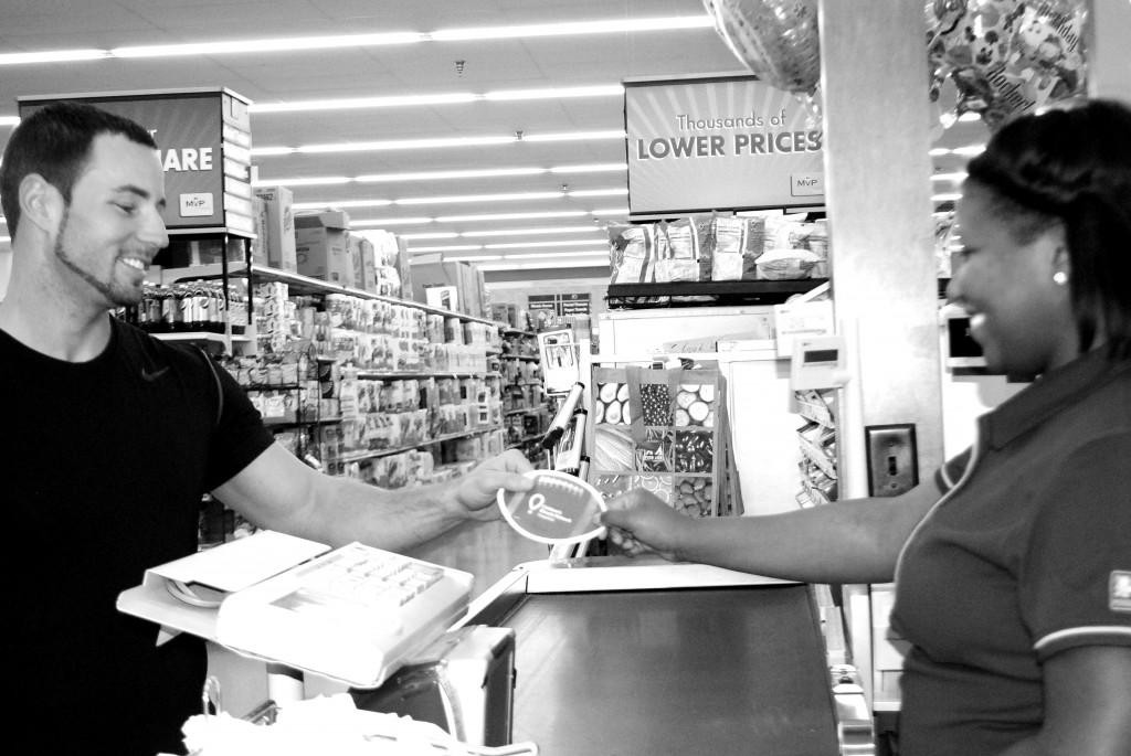 Helonia Gowans, a Food Lion employee, passes off proof of donation to customer Shawn Fitzpatrick. Photo by Deborah Gardner. 