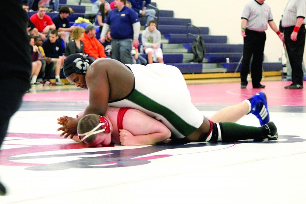 Junior Carlos Littles wrestles during the 2013 Central District Tournament a year before his potential career-altering injury. Littles will be starting the school's season as planned with no delay in matches. Photo by Kristen Schwalm. 