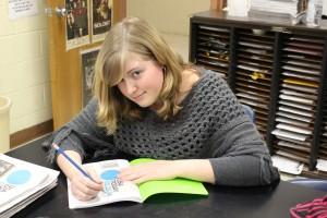Sophomore Lexi Korkos uses her free time during school to start her homework. Korkos has just been hired at Red Lobster in addition to honors classes and activities. Photo by Ebony Gilchrist. 