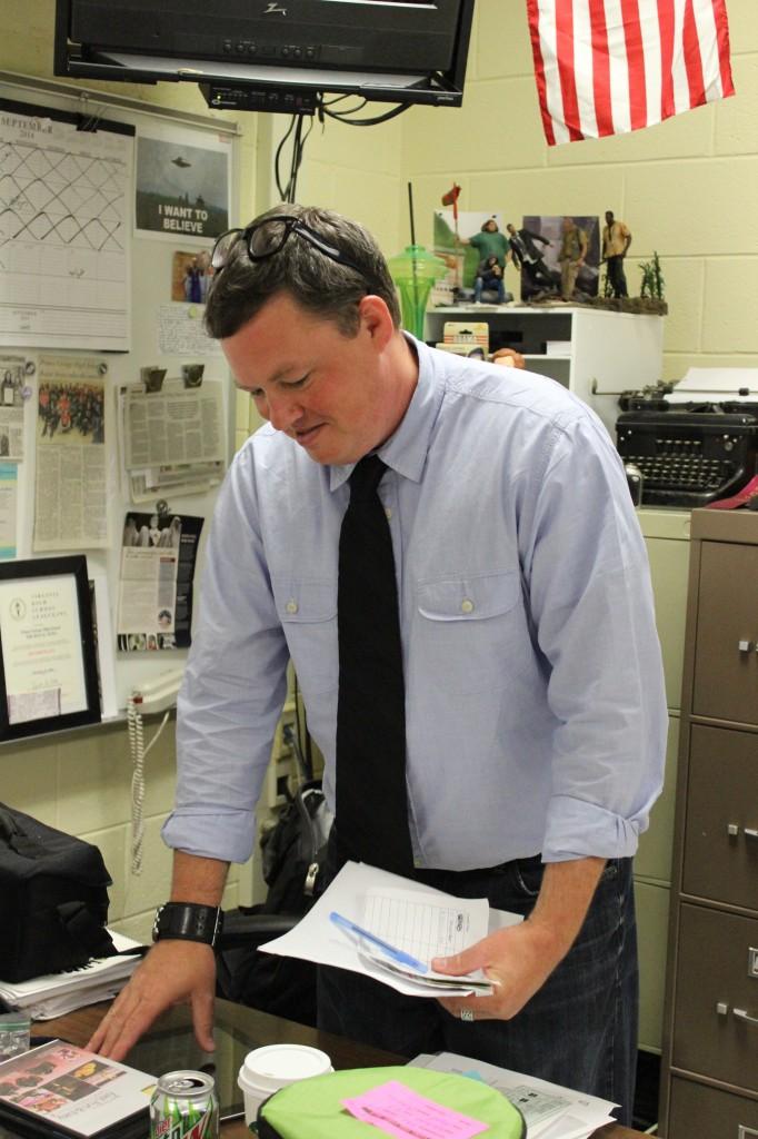 Media advisor Chris Waugaman searches for files to help his students create the newspaper.