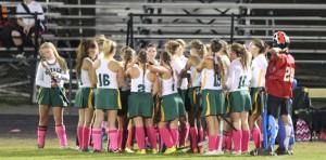 The varsity field hockey team meets on the sideline during a timeout. Photo by Travis Temple.