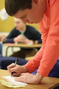 Junior Kevin Foster fills out a paper slip that accompanies his Adopt a Soldier donation. Photo by Tyneisha Griffin.