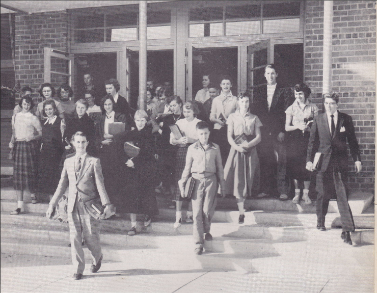 Pictured above is a photo of students from the high school in 1954. Male students at this time dressed in coats and ties, and females wore dresses or long skirts. Photo from Peerage 1954. 