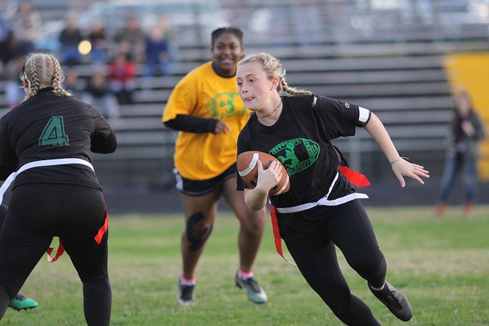 Senior running back Sydney Bartlett rushes the ball around the end of the line. The seniors defeated the juniors 16-9.
