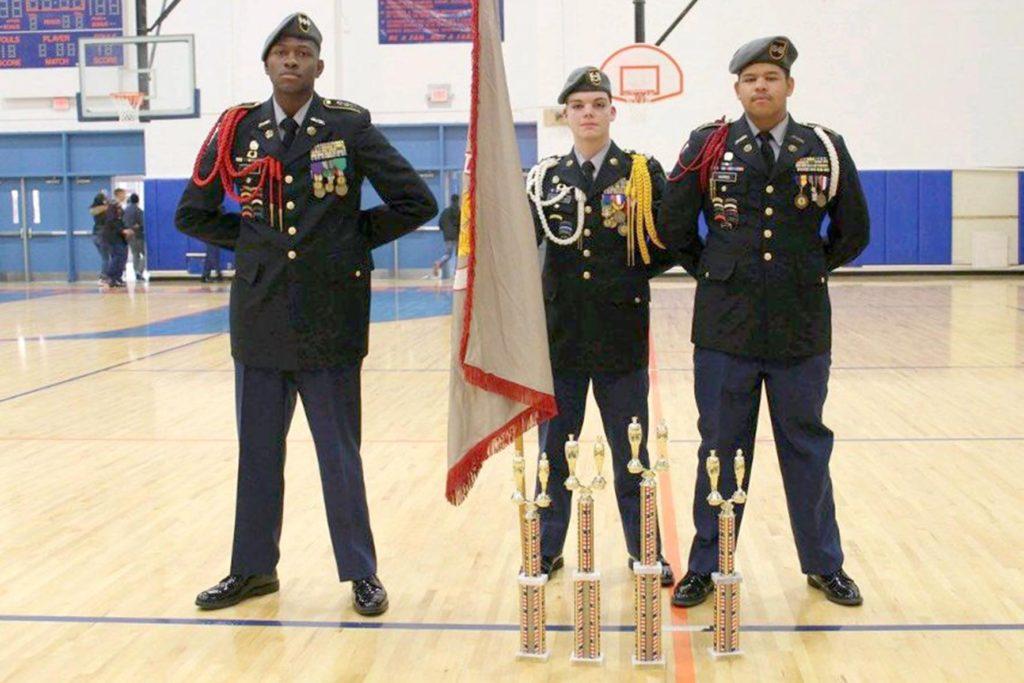Cadet Captain Chris Bethea, Command Serjeant Major Mason Kienzler, and Cadet 1st Lieutenant Darius Harris stand with their trophies. The team placed third in Color Guard & Armed Platoon, second in Unarmed Inspection, & first in Armed Squad competitions. Photo by Emily Rolon.