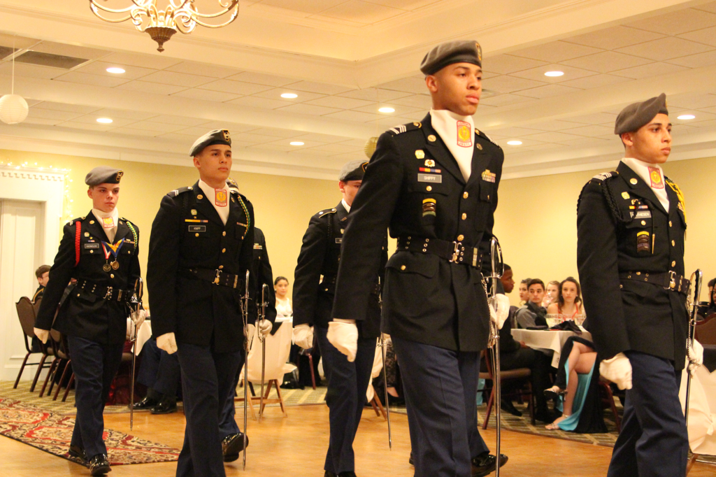 The honor guard marches in for the Military Ball in 2017 to set up the saber tunnel. The saber tunnel is only for seniors to walk through and have their names read off. 
Photo by Taylar Bauschatz. 