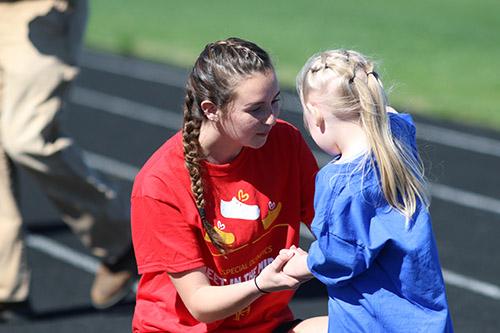 Senior Abby Warren helps an elementary student at the Meet In The Middle 2019 event. Photo by Monica Thompson.