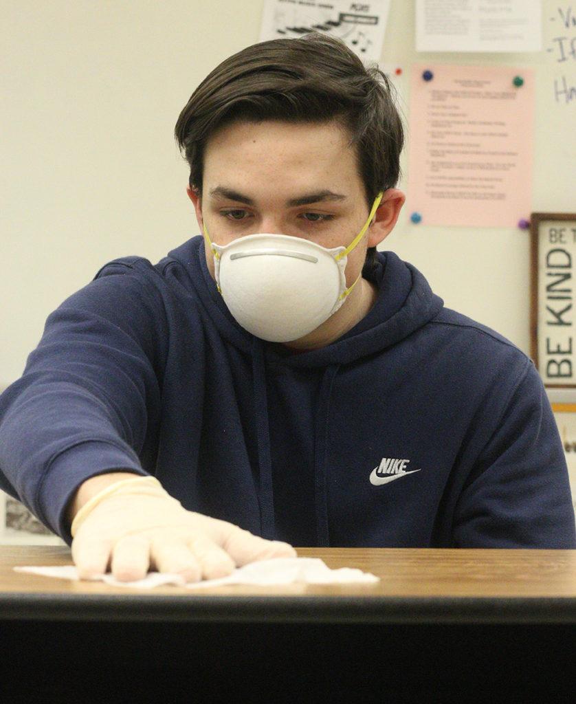 
Students throughout the school have been going home sick. Sophomore Dylan McCauley-Cook takes precautions by cleaning off his work space.
Photo by Allison McCauley-Cook.