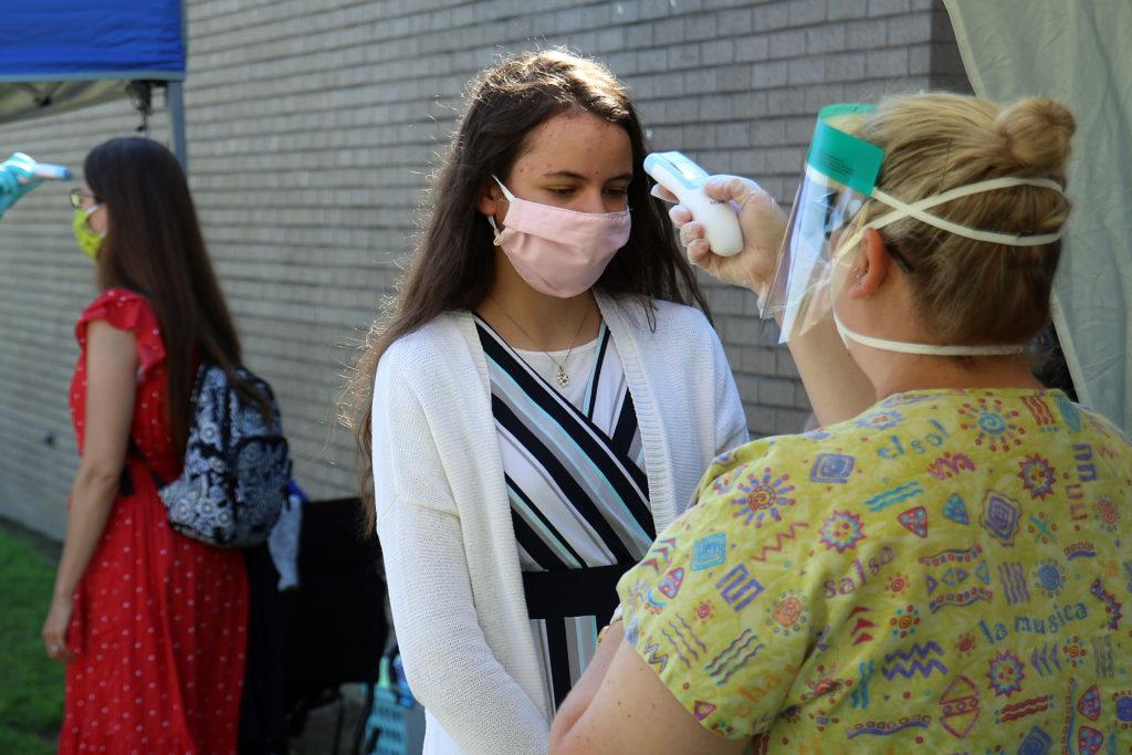 Nurses checked temperatures at the 2020 graduation. Students who attend school in person in the fall will be encouraged to wear masks in the halls and in the classrooms.