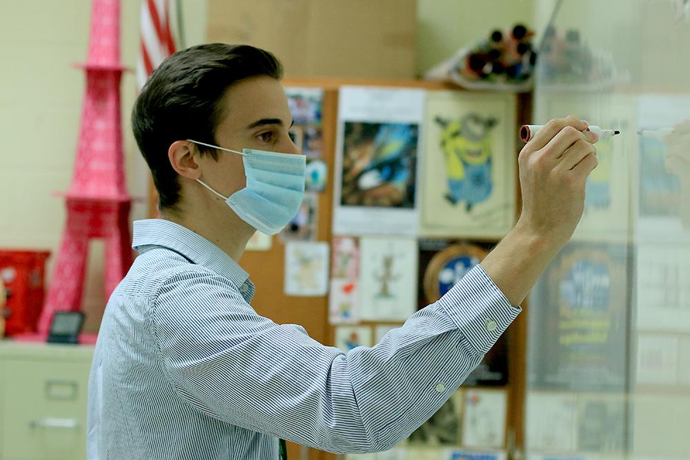 First year Spanish teacher Dalton Diaz works at the board, as he maintains CDC guidelines by wearing a mask.