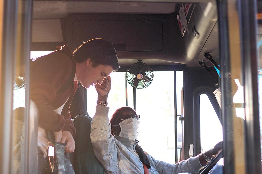 Bus driver Mr. Jones checks sophomore Owen Tarnaski’s temperature before disembarking the bus. Bus drivers are required to not only check temperatures of all riders, but they also must clean and disinfect buses after runs. Photo by Maclay Cerny.
